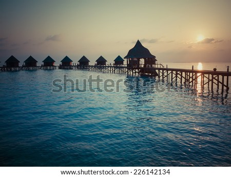 Silhouette of lodges in the sea at sunset. Maldives,with a retro effect