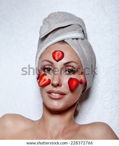 beautiful young woman in towel with a strawberry mask