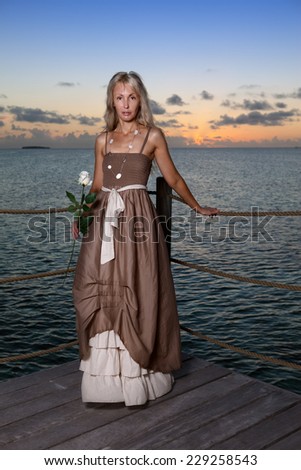 The young beautiful woman  on a wooden platform over  the sea