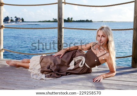 The young beautiful woman  on a wooden platform over  the sea
