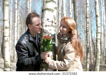 Man prepared bouquet in gift woman, In bright it solar shine through branches of trees