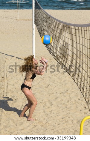 Attractive woman plays in beach volleyball