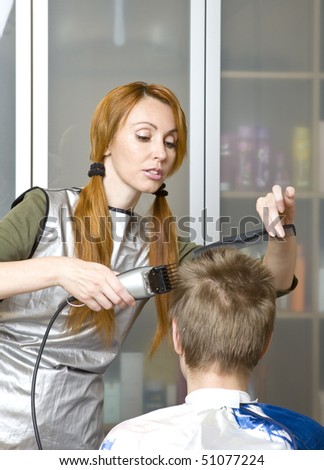 Pretty woman hairdresser cuts client