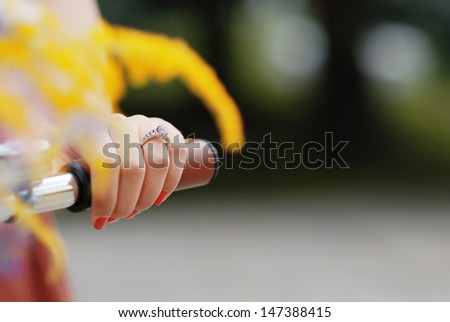 Hand on young woman on the bicycle handlebar and blurred background