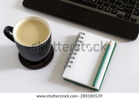 Blank white page, green pencil, coffee mug and laptop