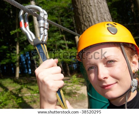 Extreme sport woman with climbing gear sliding on a cable