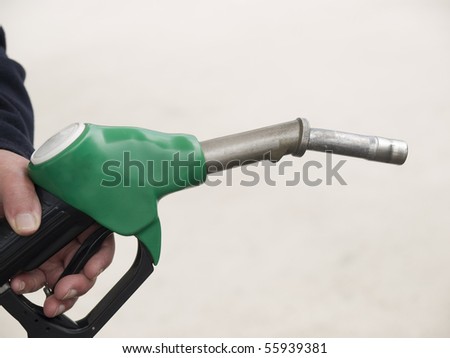 Hand holding nozzle of fuel hose