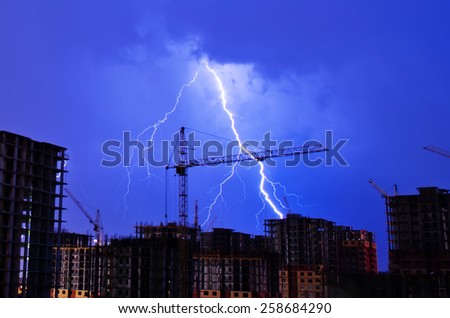 Lightning storm crane weather industrial city building construction night flash