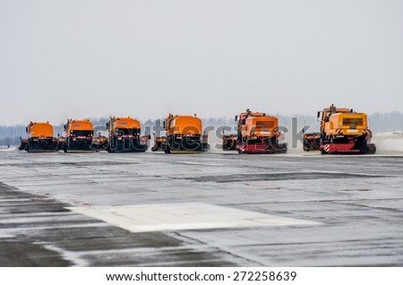 Snow machines on the asphalt runway rain snow removal. Russia, Tyumen city, Airport Roschino 13 March 2014