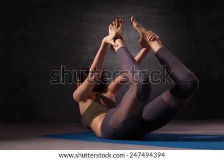 Mature woman practicing yoga in bow pose