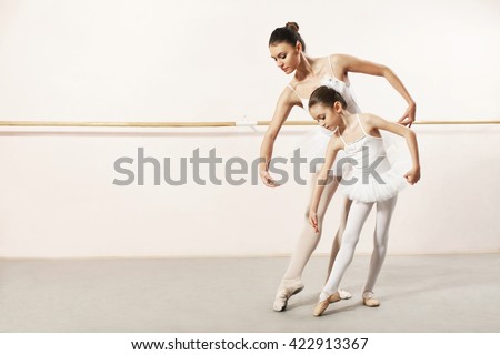 Little ballerina dancing with ballet teacher in dance studio