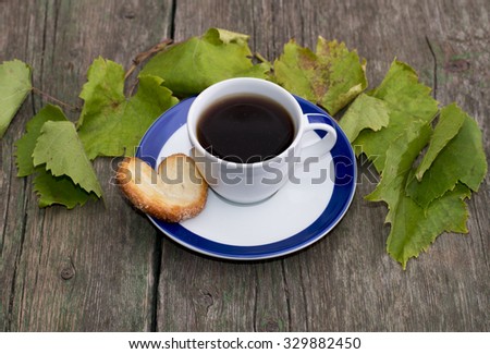 cup of coffee on a saucer, one cookies, it is decorated with grape leaves, a still life, a subject drinks