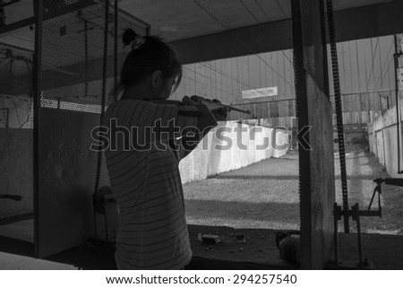 Women rifle shooting in the indoor Shooting Range black and white tone.