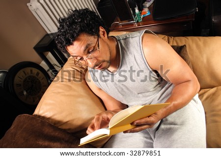 A man sitting on his couch reading a good book