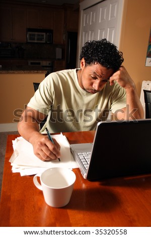 A man stressed out about paper work with laptop computer