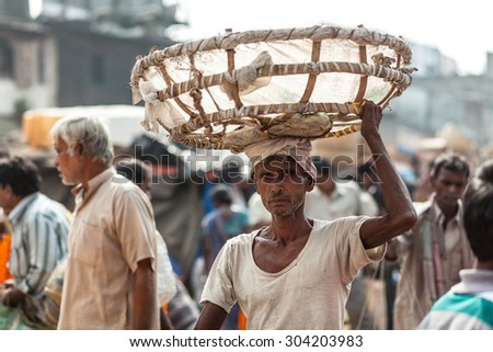 CALCUTTA, INDIA - NOVEMBER 20, 2014: Indian man carrying the empty basket on his head. Flower market, Kolkata, India.