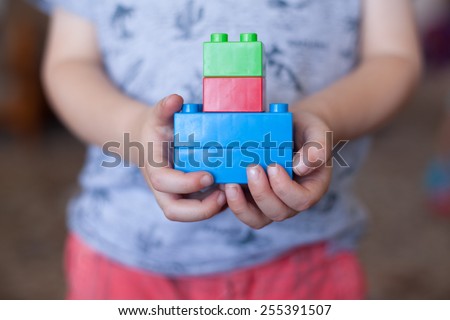 child holding lego blocks