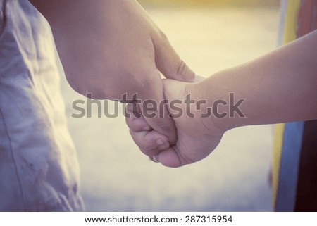 Close up hand , a boy holding a child hand , nature and sunset b