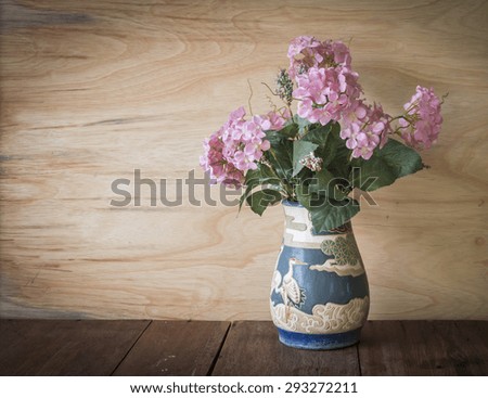 Pink flower in vase with wooden background