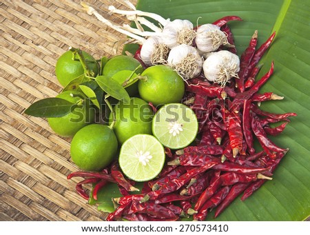 Chili, garlic and lemon on wooden basket, Asian herb