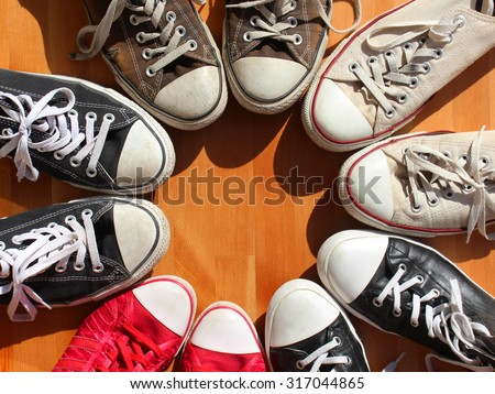 Red, black and white sneakers standing in the circle, view from above