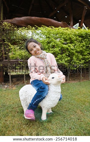 The girl is riding the sculpture sheep