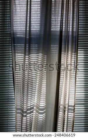 white curtain with blinds on a sunny day