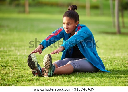 Young girl with an active life style busy stretching in the park early in the morning
