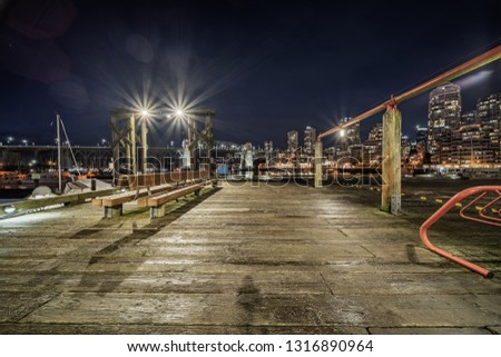 empty wooden dock with skyline background at night, vancouver, canada.
