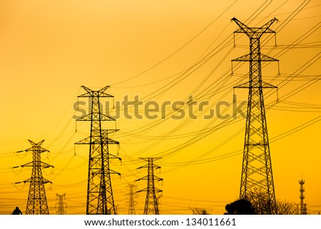 High voltage towers against the sunset background.