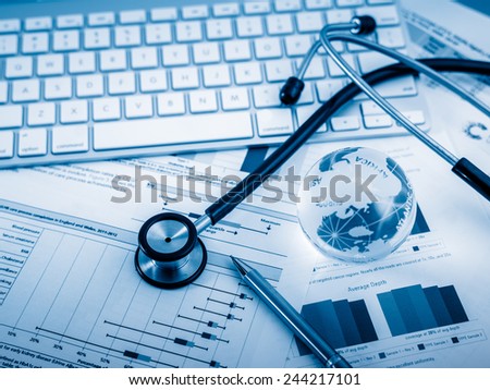 Stethoscope with financial statement on the desk.