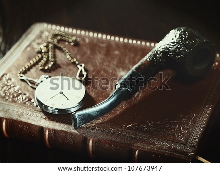 Abstract retro still life with old leather covered book and watch