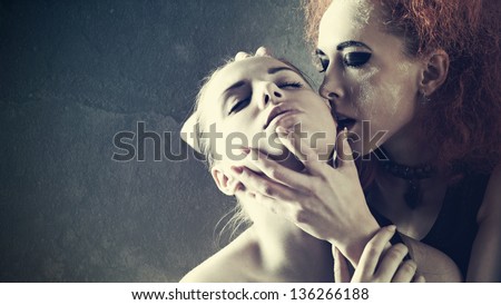 Vampire\'s kiss. Fantasy female portrait against dark grungy backgrounds