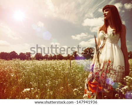 Beauty young woman walking around the summer meadow