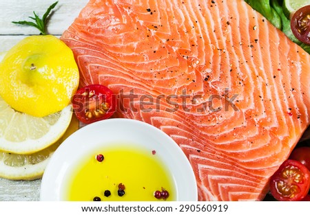 Closeup of fresh raw salmon fillet on wooden rustic table. Top view. Healthy food, diet or cooking concept.
