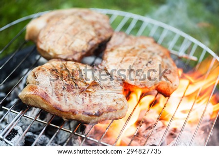 Top sirloin steak on a barbecue, shallow depth of field. Summer BBQ closeup, outdoor grill concept. Grilled steak meat cooked on carocal.