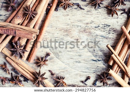 Artistic closeup of cinnamon and star anise seeds on a wooden background. Sunny still life photo.