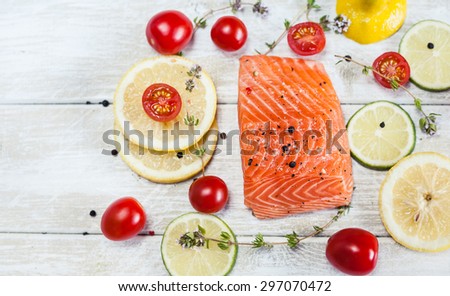 Fresh raw salmon fillet on wooden rustic table - top view. Healthy food, diet or cooking concept.