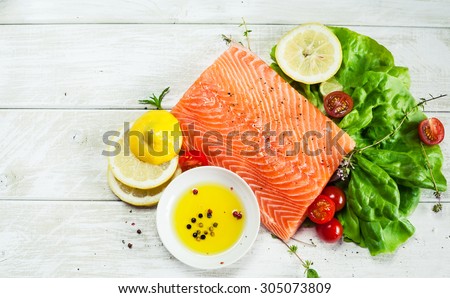 Fresh raw salmon fillet on wooden rustic table with place for your text. Top view seafood photo. Healthy food, diet or cooking concept.