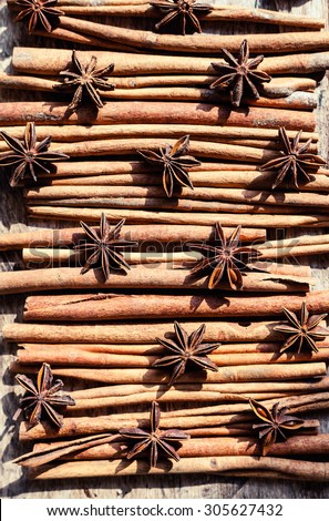 Artistic closeup of cinnamon and star anise seeds on a wooden background. Sunny still life photo. Top view