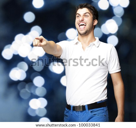 portrait of a young man joking against a blue light background