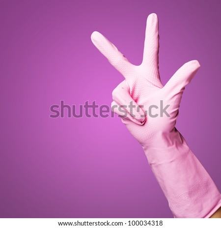 pink gloves of maid gesturing number three against a pink background
