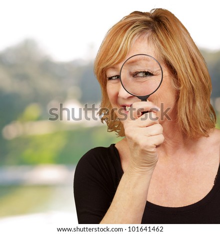 portrait of middle aged woman looking through a magnifying glass
