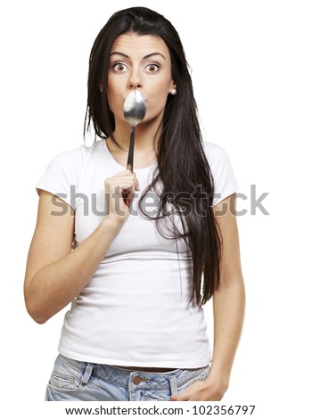 woman covering her mouth with a spoon against a white background