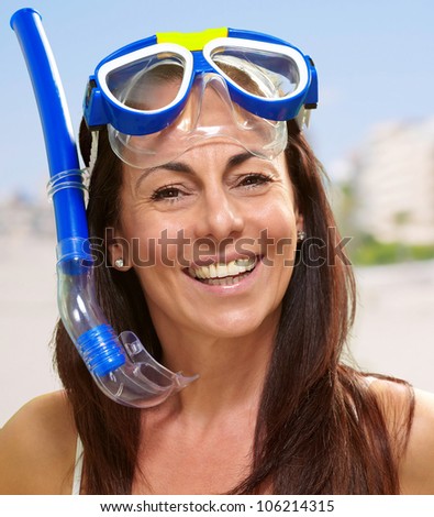 portrait of a happy middle aged woman wearing snorkel and goggles