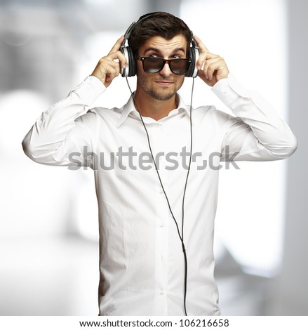 portrait of a young man listening to music using headphones indoor