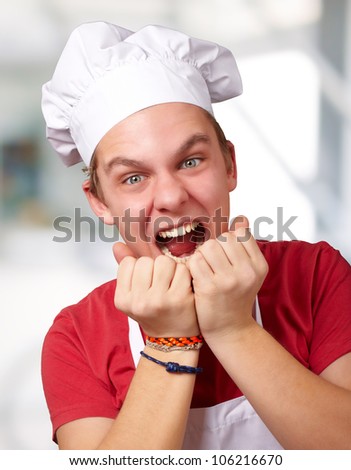 portrait of a young cook man screaming indoor