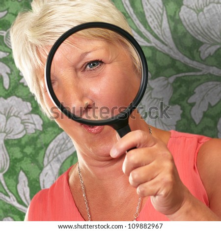 Senior Woman Looking Through A Magnifying Glass, Indoor