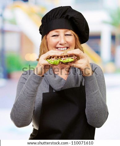 Middle aged cook woman holding a vegetal sandwich at mall