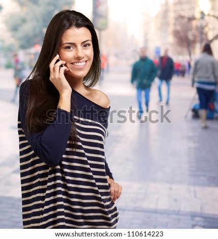 portrait of young woman talking on mobile at street